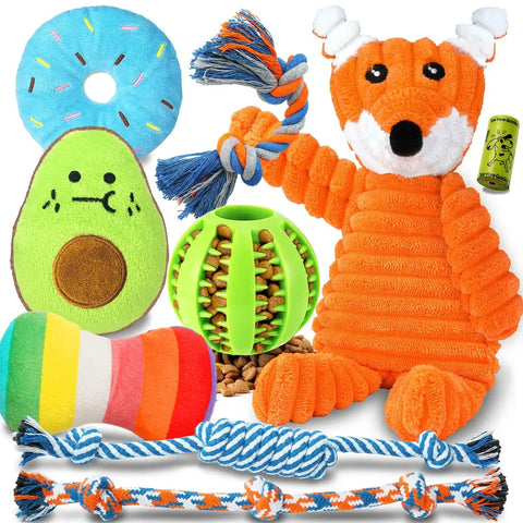 A 9-pack assortment of puppy chew toys including a stuffing-free fox squeaky toy, plush avocado and donut, colorful rope toys, a green treat dispensing ball, and dog poop bags.