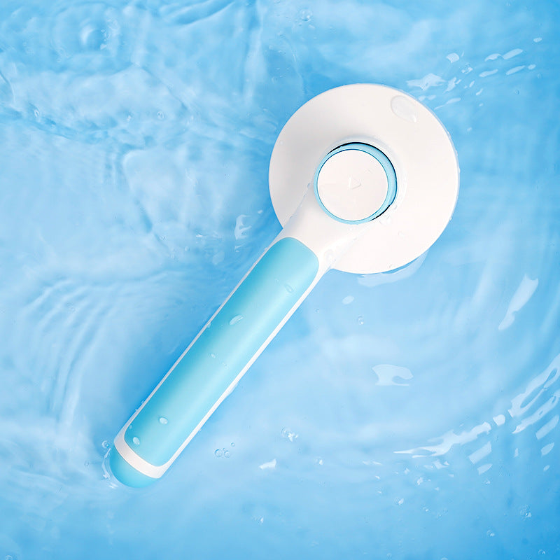 Blue handheld cleaning tool with a white circular head floating on water