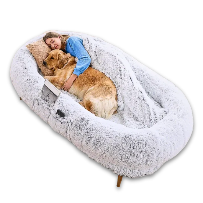 Large fluffy pet bed with a person and dog inside on a white background