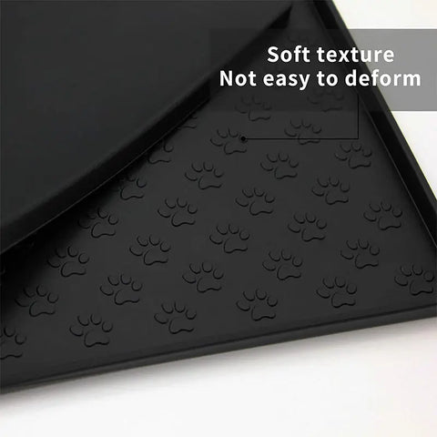 Black pet mat with raised paw print pattern for feeding.