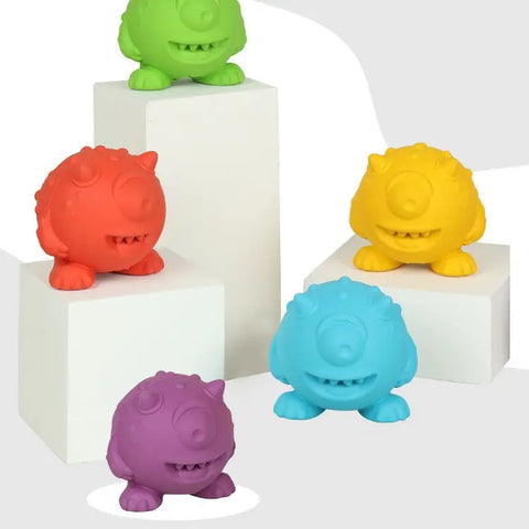 Blue, red, green, purple, and yellow monster-shaped pet toys on white background