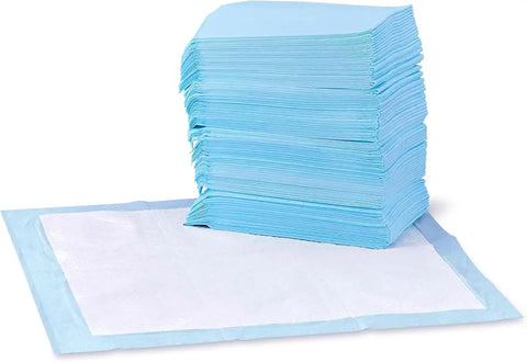 A large stack of blue leak-proof dog pee pads next to an unfolded white training pad