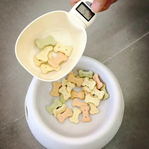 Digital scale measuring dog treats into a bowl for portion control and nutrition