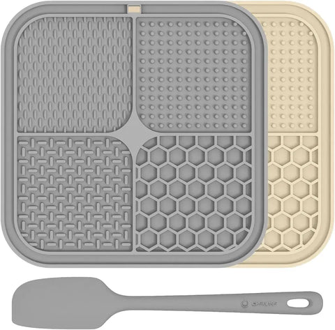 Light grey and beige quad-textured dog anxiety relief lick mats shown with a silicone spatula.