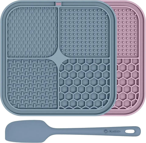 silicone dog lick mats in slate blue and dusty pink with a matching blue spatula.