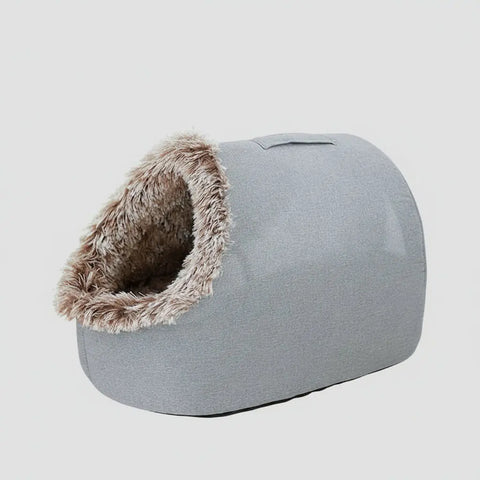 Gray pet bed with fluffy entrance on light background.
