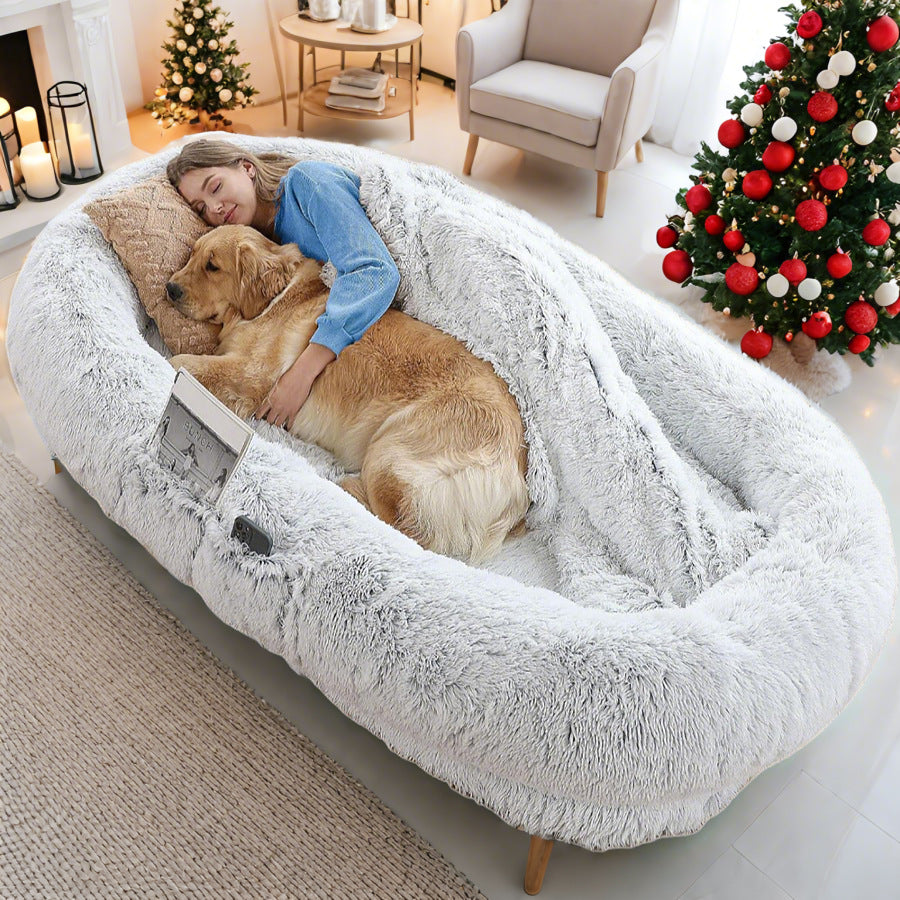 A large white plush pet bed with a removable mattress, shown with a person cuddling a dog inside.