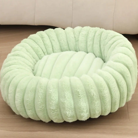 Light green round pet bed with cozy plush filling and decorative ribbed texture