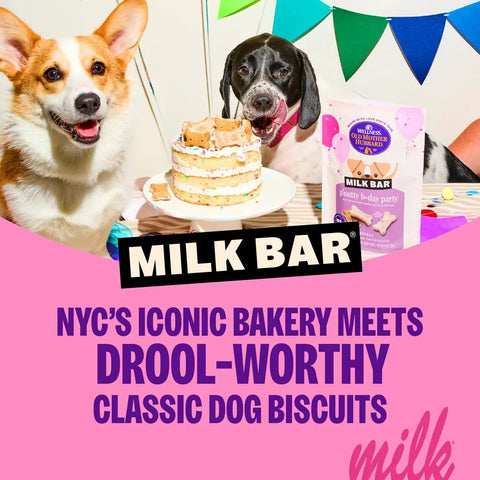 Two dogs celebrating with a Milk Bar birthday cake and Wellness Old Mother Hubbard p'nutty b-day party dog biscuits.