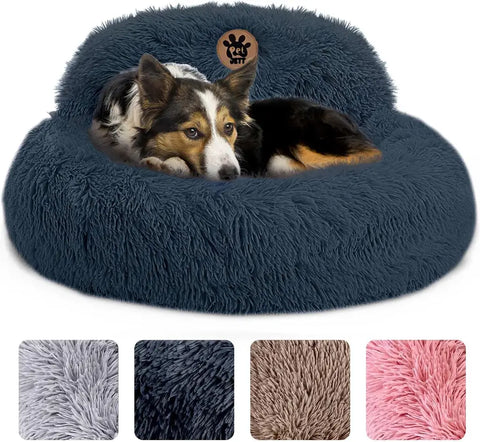 Small dog resting in a navy blue plush calming donut bed with raised backrest