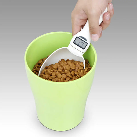 Person using a digital measuring scoop to portion kibble into a food container