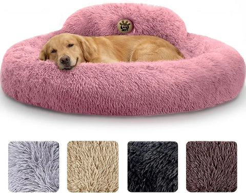 Golden retriever sleeping peacefully in a large plush pink calming donut dog bed