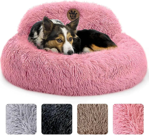 Medium dog relaxing in a bright pink fuzzy donut dog bed with raised bolster