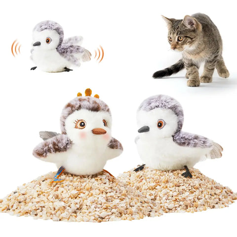 Pair of female and male sandpiper interactive flapping bird cat toys sitting on sand with a kitten looking on