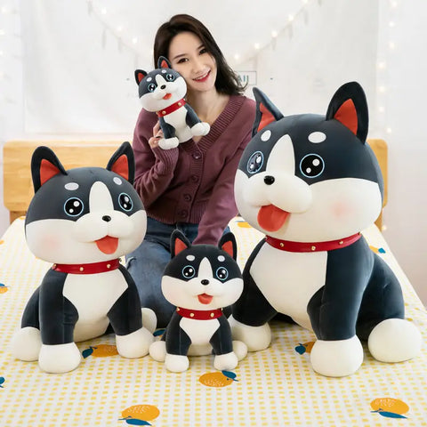 Woman holding a small plush dog toy, surrounded by larger plush dogs of various sizes
