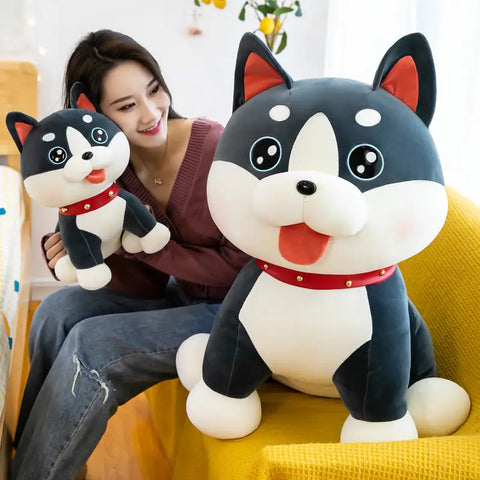 Woman smiling as she holds a large, soft plush dog toy on a yellow couch