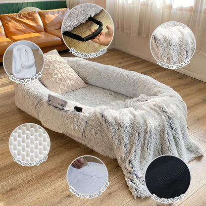 Portable pet sofa with handle and removable cover on wooden floor.