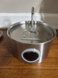 Close-up of an opened gray filter tray compartment showing how a multi-stage replacement filter fits inside the pet water fountain lid.