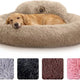 Golden retriever sleeping comfortably in a large beige soft faux fur donut bed