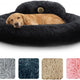Golden retriever resting inside a large black fluffy round donut pet bed