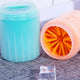 Blue container with pink lid featuring orange bristles on textured surface.