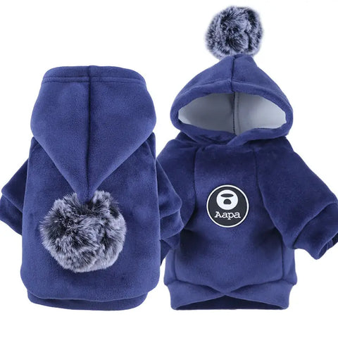 Blue pet hoodie with pom-poms on white background.