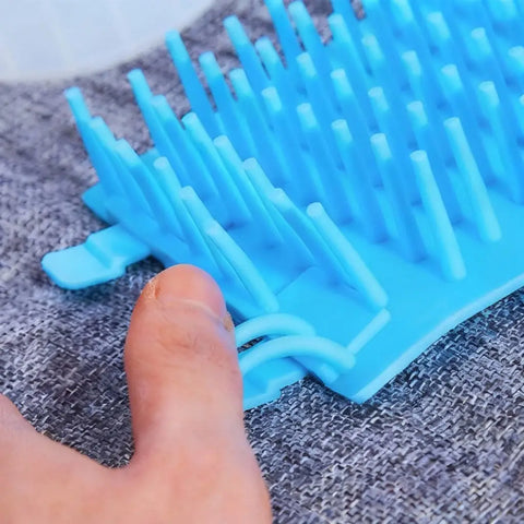 Blue silicone tool with textured surface on textured gray background.
