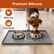 Beagle dog eating kibble from a stainless steel bowl placed on a premium grey food-grade silicone mat.