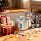 A tabby cat drinking from a stainless steel water fountain next to Christmas presents.

Image 6