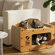 Two cats playing and resting inside a vintage radio-style wooden cat house scratcher in a living room.
