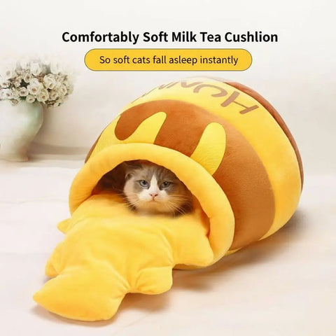 Cat inside a plush honeycomb toy on a wooden floor.