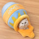 Cat inside a plush honeycomb toy on a wooden floor.