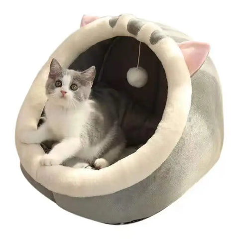 Cat lying in a gray and white pet bed with cat ears.