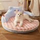 Cat lying on a pink and blue pet bed with cartoon design