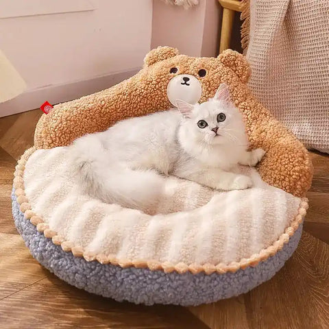 Cat lying on fluffy bear-shaped pet bed with soft texture.