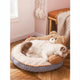 Cat lying on plush pet bed with bear design in cozy room.