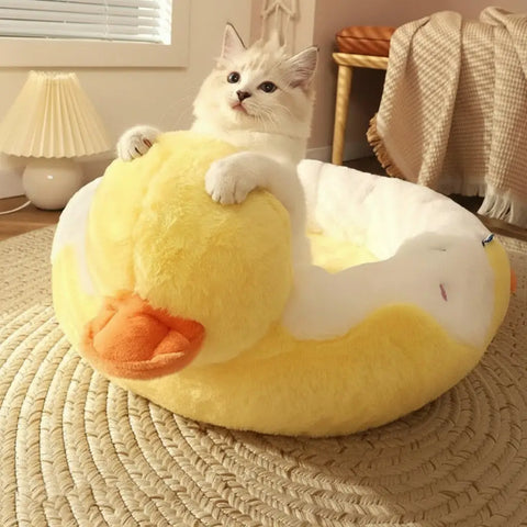 Cat lying on yellow duck-shaped pet bed in cozy room.