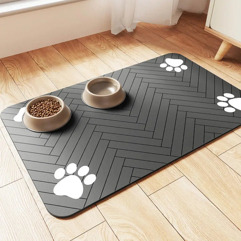 Charcoal grey pet food mat with white paw prints and herringbone texture on wood floor.