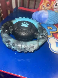 Chewed blue camo ring toy on play table