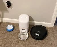 Customer review photo showing black Bsemax wet food feeder set up alongside a dry food dispenser and water bowl