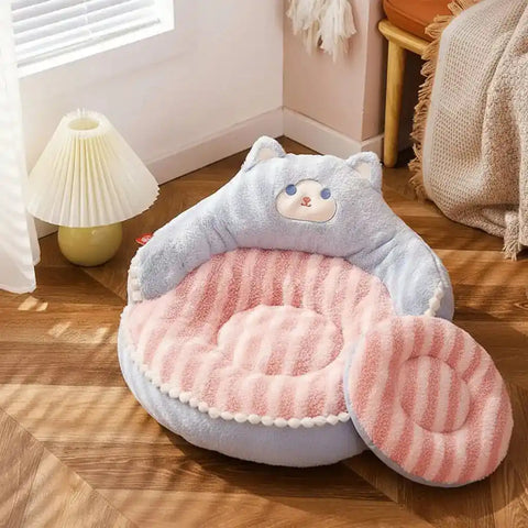 Cute pet bed with a plush blanket on wooden floor.