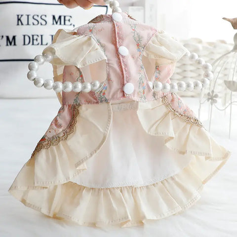 Decorative dress with floral patterns and pearl accents on white.