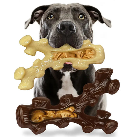 Pitbull dog holding an antler-shaped durable nylon chew toy filled with peanut butter.