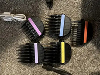 Five color-coded guide guard combs and a cleaning brush accessory included in the cordless pet hair trimmer set.