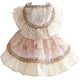 Dog dress with floral pattern and lace details on white background.