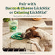 Dog licking treat spread from green LickMat next to a bag of Woof LickMix on a kitchen counter.
