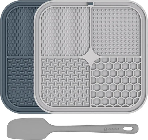 Two-pack silicone dog lick mats in grey and dark blue with a matching grey spatula.