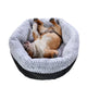 Dog lying on a gray pet bed with a white background.