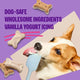 Close up of a Corgi licking a spatula next to wholesome dog-safe biscuits with vanilla yogurt icing.
