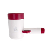 Dog using a paw washing cup with a person assisting on a white background